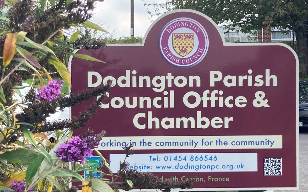 Sign that says "Dodington Parish Council Office and Chamber". The sign is outside, purple coloured with yellow text.